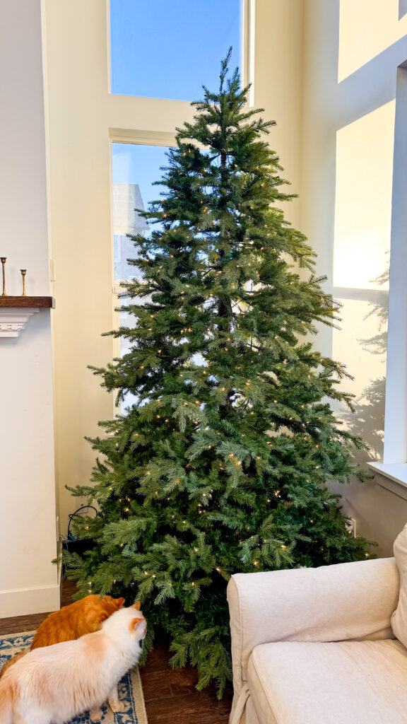 An artificial Christmas tree with bare spots and gaps in the branches of the tree.