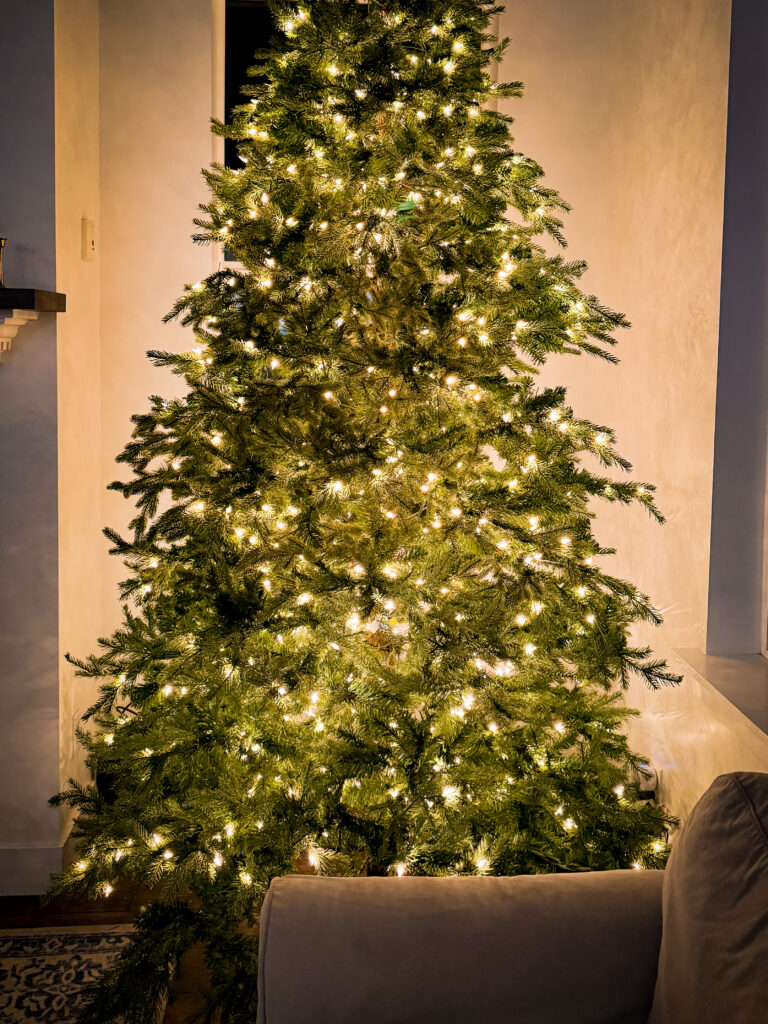 An artificial Christmas tree with the bare spots and gaps in the branches filled in with additional artificial pine branches.