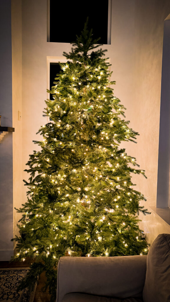 An artificial Christmas tree with the bare spots and gaps in the branches filled in with additional artificial pine branches.